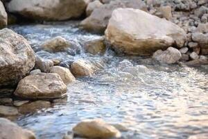 A stream of water flows over rocks in a stream photo
