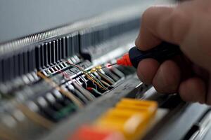 A person is using a screwdriver to fix a circuit board photo
