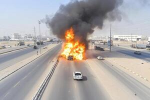 A burning vehicle on the highway with smoke coming out of it photo