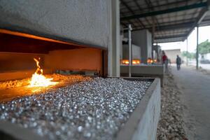 A man is standing in front of a fire with a bucket of gravel photo