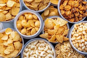 A variety of different types of snacks in bowls photo