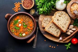 Lentil soup with bread and vegetables on a dark background photo