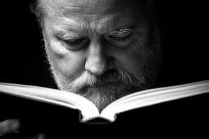A man with a beard reading a book photo