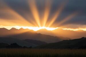 Sunbeams shine through the clouds over a mountain range photo