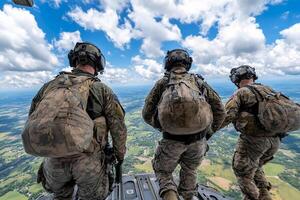 Three soldiers standing on the side of a helicopter photo