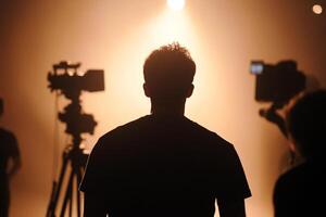 A man standing in front of a camera and a spotlight photo