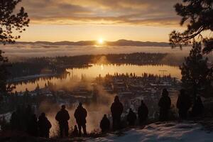 A group of people standing on a hill overlooking a lake photo