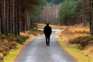 A man walking down a path in the woods photo