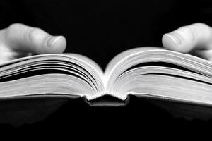 A person holding an open book in their hands photo