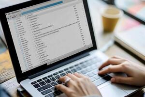 A person is typing on a laptop with a list of files photo