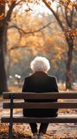 Autumn Reflection Senior Woman on Park Bench photo