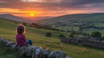 Child Watching Sunset Over Rolling Hills and Fields photo
