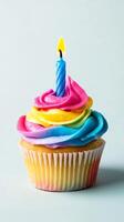 Colorful Rainbow Cupcake Topped with a Birthday Candle photo