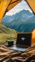 Scenic Mountain Views A Laptop Connects You to the World While Camping in Nature, Offering Digital Nomad Freedom and a Blend of Adventure and Modern Technology photo
