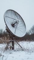Icy Satellite Dish A Winter Telecommunications Landscape. Frozen Antenna in a Snow-Covered Field. Communication Technology in Cold Weather. Snowy Rural Scene. photo