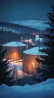 Winter's Embrace Industrial Tanks in a Snowy Landscape, Fueling the Cold with Energy and Petroleum, a Twilight Scene of Snowy Mountains and a Remote Facility photo