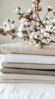Natural Linen Fabric Stack with Cotton Flowers photo