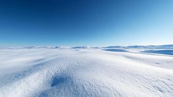 Majestic Winter Landscape with Snow-Covered Hills and a Clear Blue Sky photo