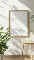 Empty Frame on a Light Beige Wall with Natural Light and Plants photo