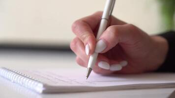A person writing on a piece of paper with a pen video