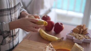 A person is peeling a banana on a table video