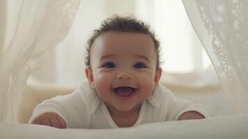 Baby smiles joyfully while lying on a bed surrounded by soft curtains in a bright room photo