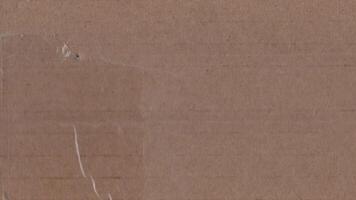 Torn cardboard box texture with visible tapes and motion grain video