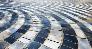 A close-up of a patterned stone pathway with curved lines. photo