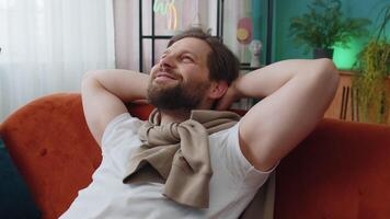 Tired young man lying down on comfortable couch, taking a rest, daytime nap relaxing falling asleep video