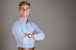 Confident young man studio portrait, arms crossed, gray background photo