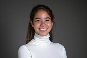 Cheerful girl smiles at the camera in a studio with a gray blurred background photo