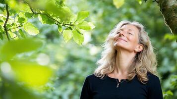 A woman is looking up at the sky in a forest photo
