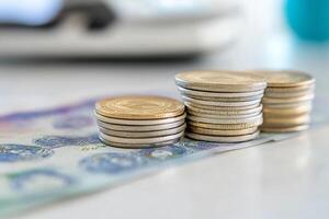A stack of coins sitting on top of a stack of bills photo