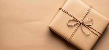 A neatly wrapped gift box tied with twine on a neutral background. photo