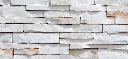 A textured wall made of white stone bricks arranged in a pattern. photo
