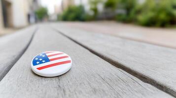 A button with the american flag on it sits on a wooden table photo