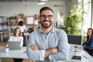 Smiling man in a modern office with colleagues working. photo