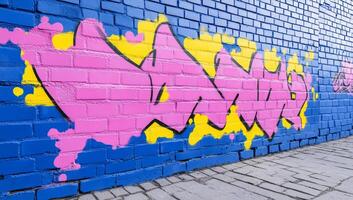 A wall with graffiti on it in a blue and yellow color photo