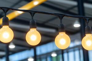 String of illuminated bulbs in a modern industrial setting. photo