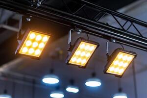 Three bright LED lights hanging from a truss in a modern setting. photo