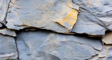 Close-up of textured slate rock surface with natural color variations. photo