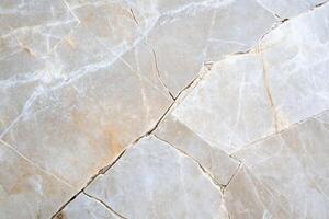 A close-up view of a light-colored marble surface with visible cracks. photo