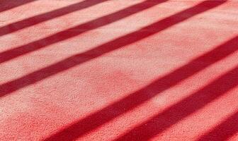 A red surface with shadows creating a striped pattern. photo