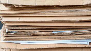 A stack of cardboard boxes with papers on top photo