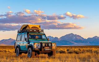 Rugged off-road vehicle with rooftop tent parked in a scenic mountainous landscape at sunset photo