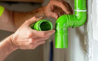 Professional HVAC technician installing bright green piping during residential renovation project photo
