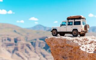 Off-road vehicle parked at the edge of a cliff in a mountainous landscape during bright, sunny weather photo