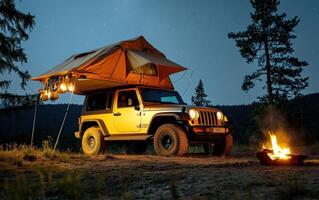 Enjoying a night under the stars with off-road camping and a cozy fire near a mountain landscape photo