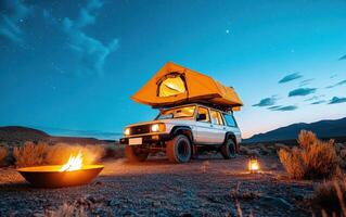 Camping under a starry night sky with an off-road vehicle and a cozy fire in the wilderness photo