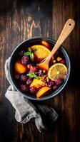 Fresh fruit bowl featuring seasonal berries and citrus in a rustic setting photo